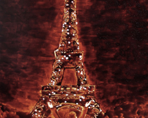 Angel Sarkela-Saur created this original "Voil&agrave;!" Coffee Art&reg; painting. It features a person gazing up in amazement at the Eiffel Tower.